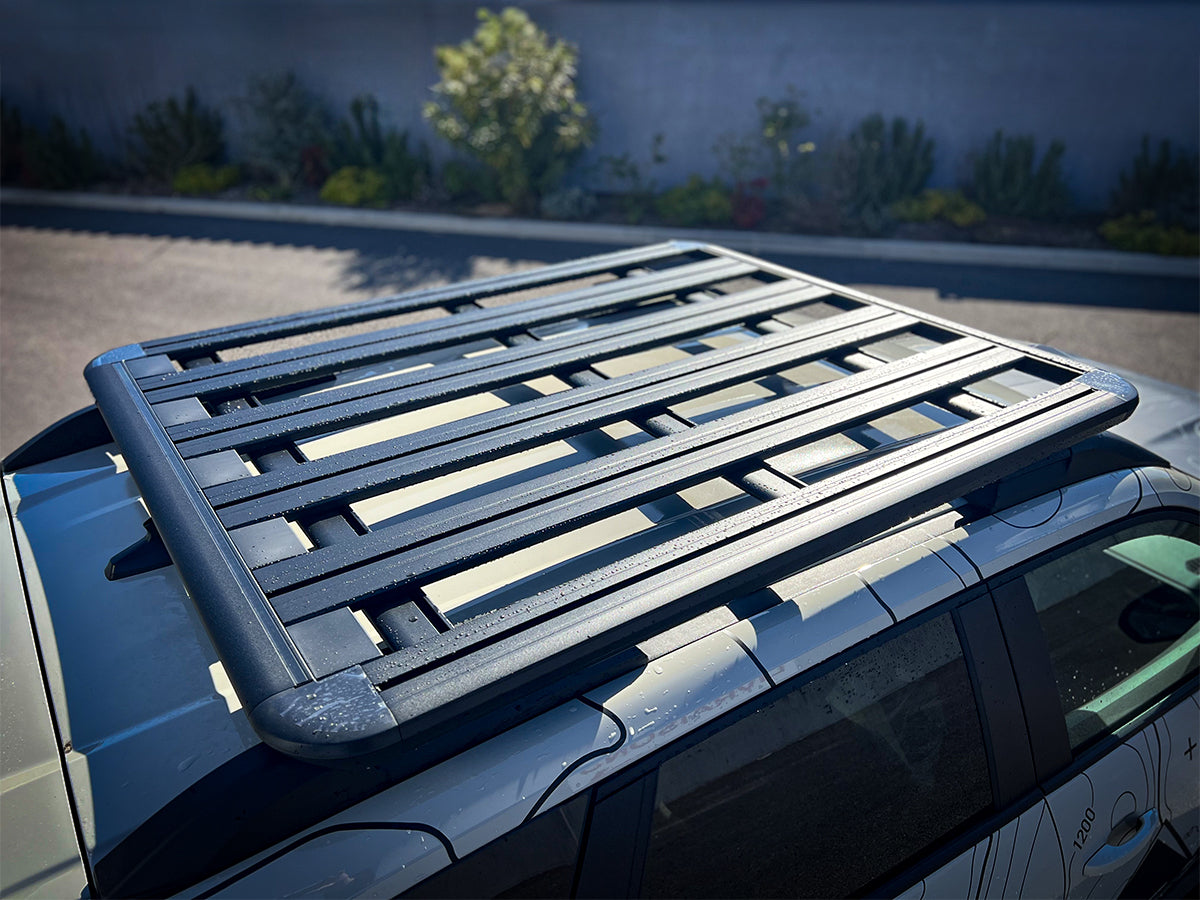 Galerie de toit Pioneer 1300x1240mm pour Dacia Duster 2024+ de la marque Rhino-Rack, vue de face sur le véhicule.