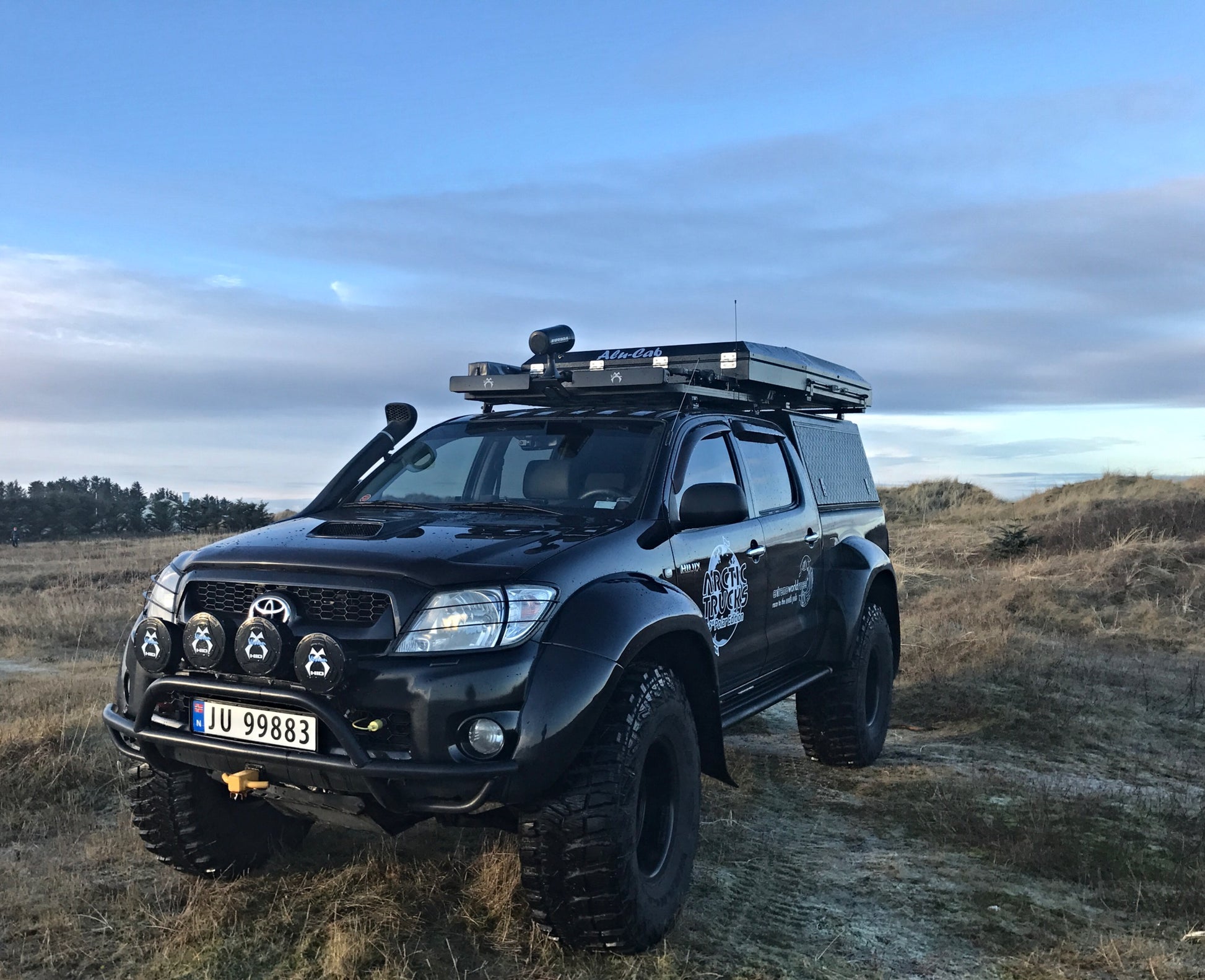 Hardtop Alu-Cab Adventure pour Toyota Hilux Revo 2016+ en aluminium, vue de face avec fenêtres et portes.